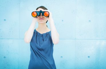 Business vision: woman holding binoculars